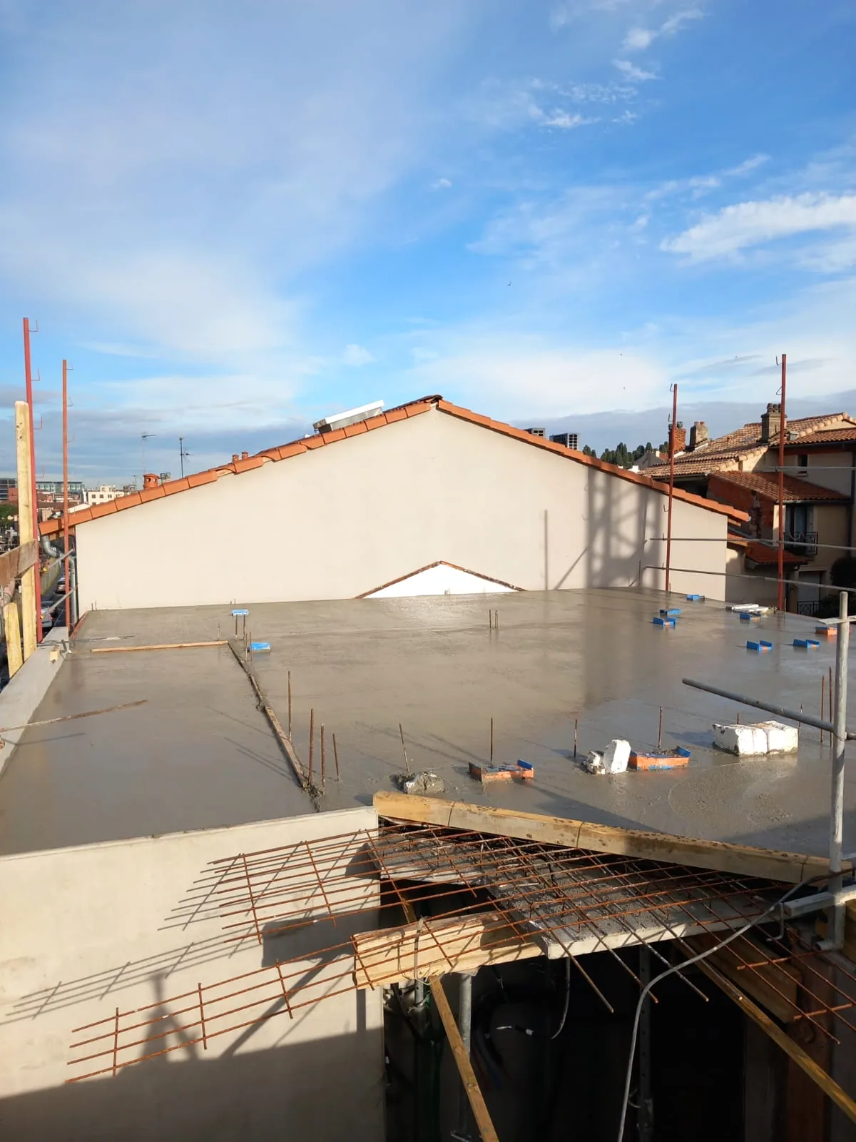 Fresh concrete slab with reinforcement visible in the foreground