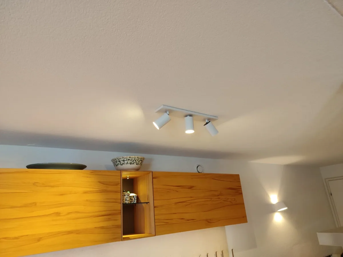 Ceiling spotlights and wall lights switched on indoors