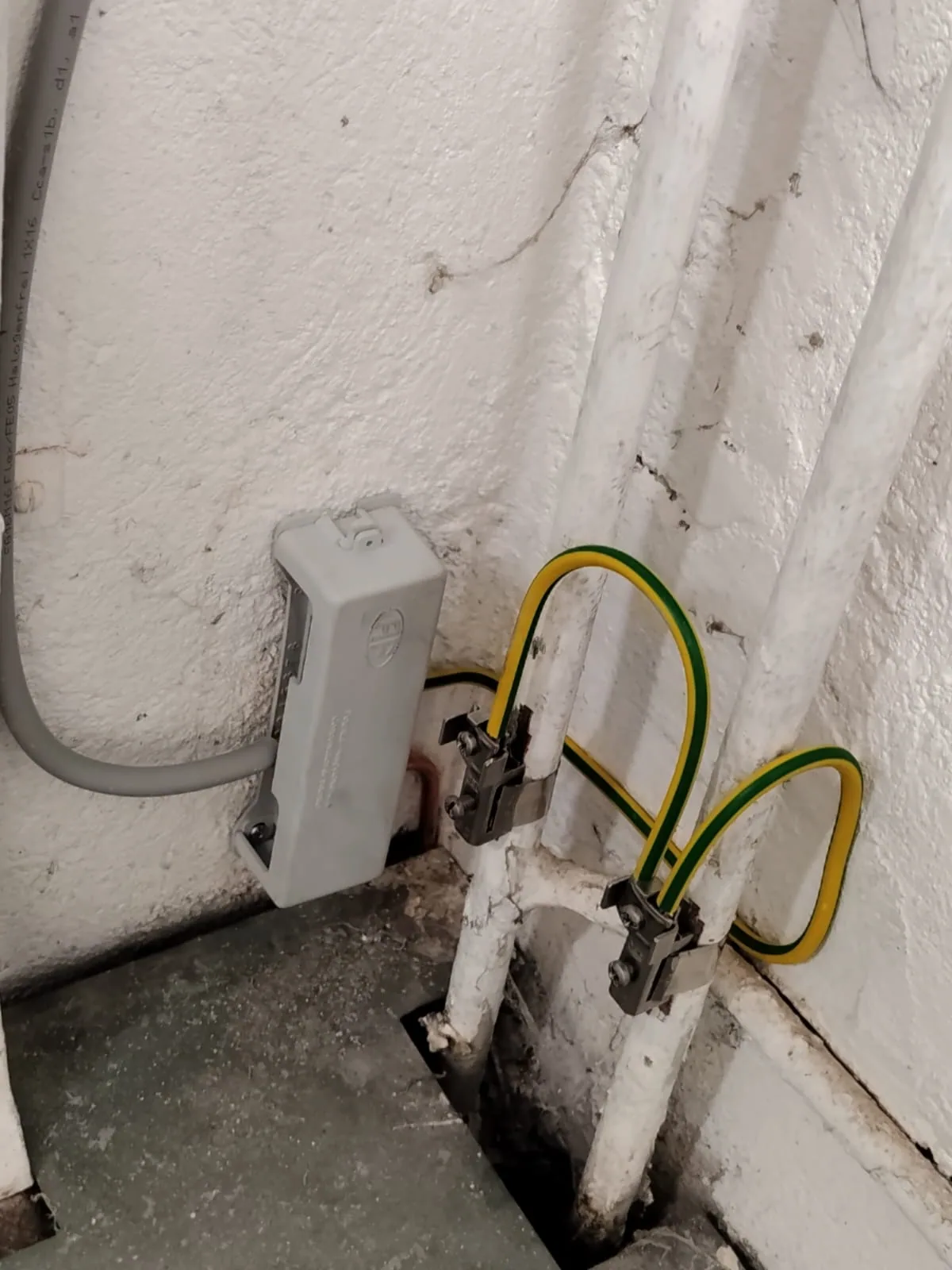 Green and yellow conductors attached to metal pipes