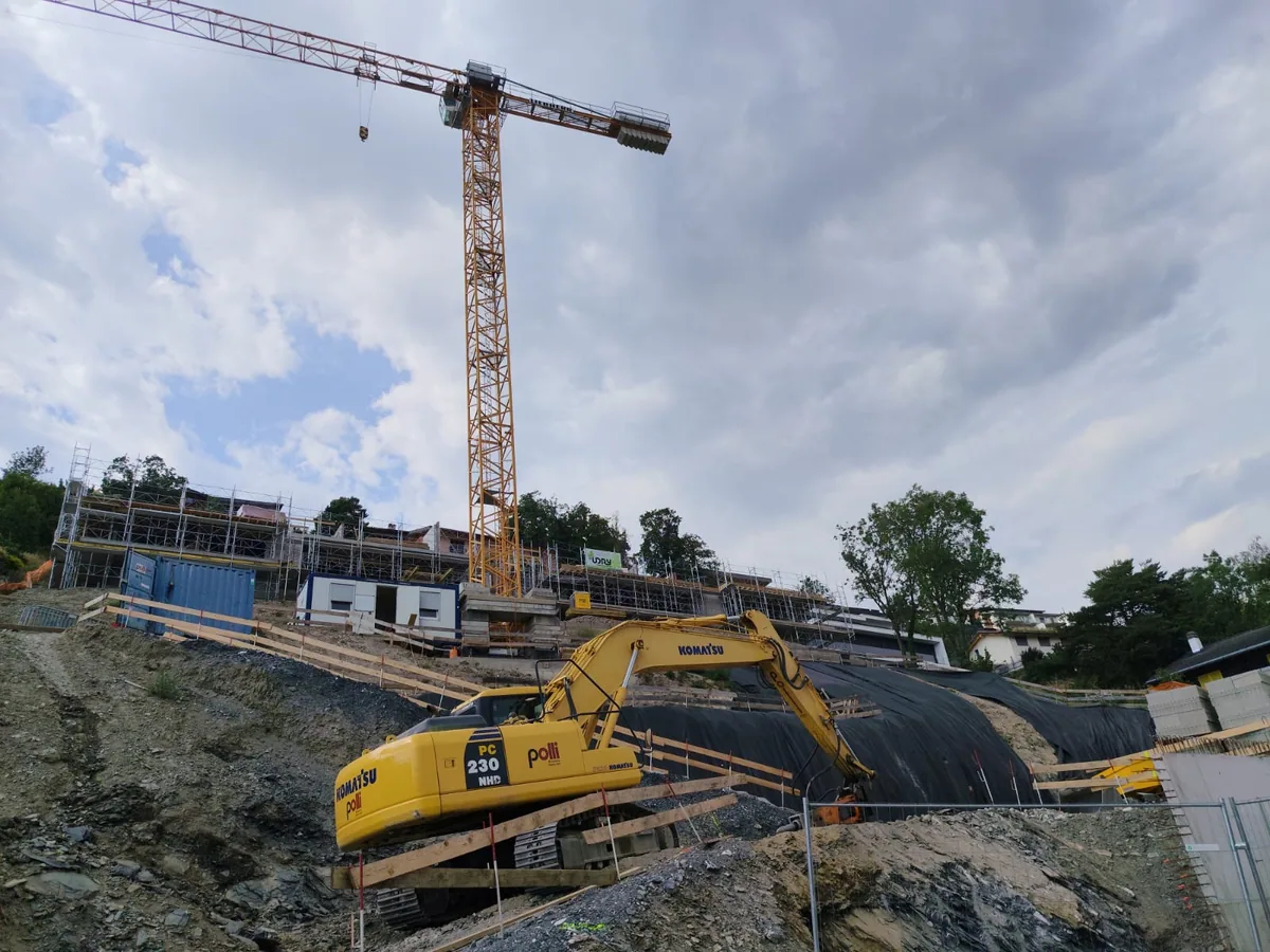 Excavator and crane on a sloping construction site